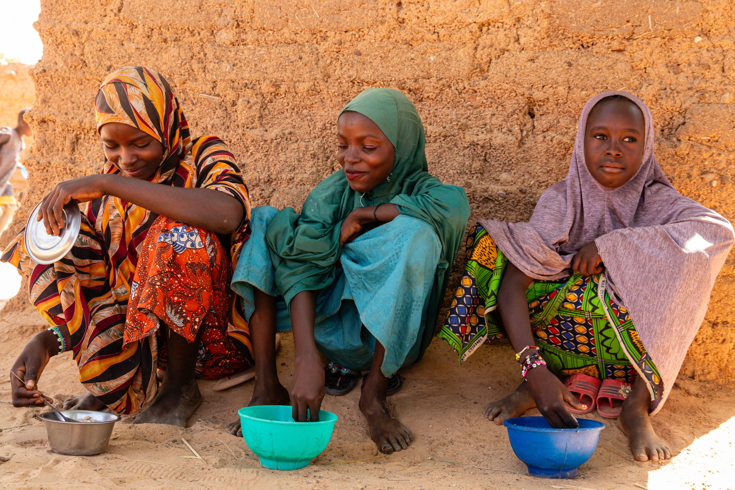 Niger. Zeinabou (Bizo's daughter), Zeinabou, and Hadjara (l to r) enjoy their meal from the school kitchen in Maradi Region